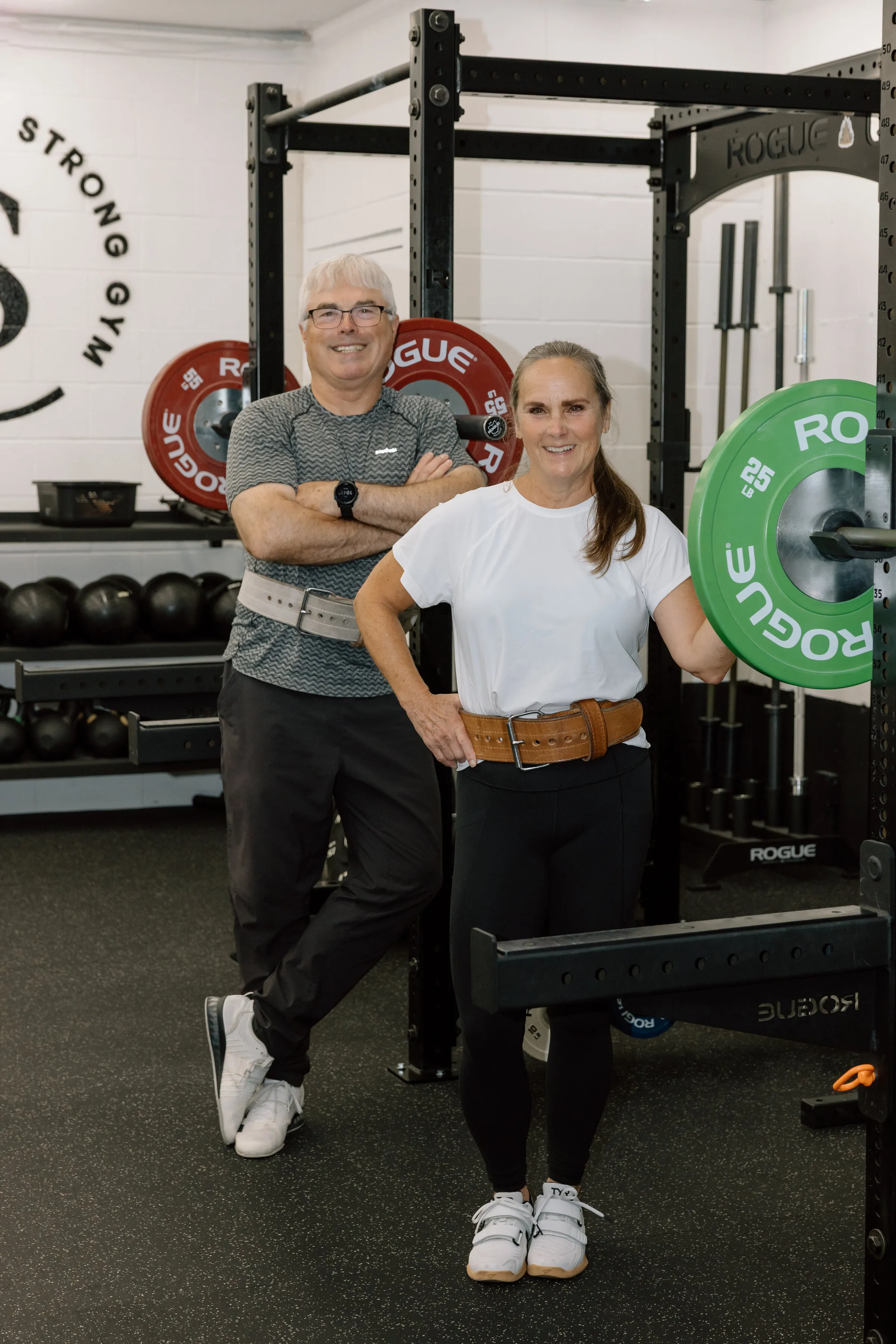 A coach and a lifter in lifting belts on the Simply Strong Gym floor