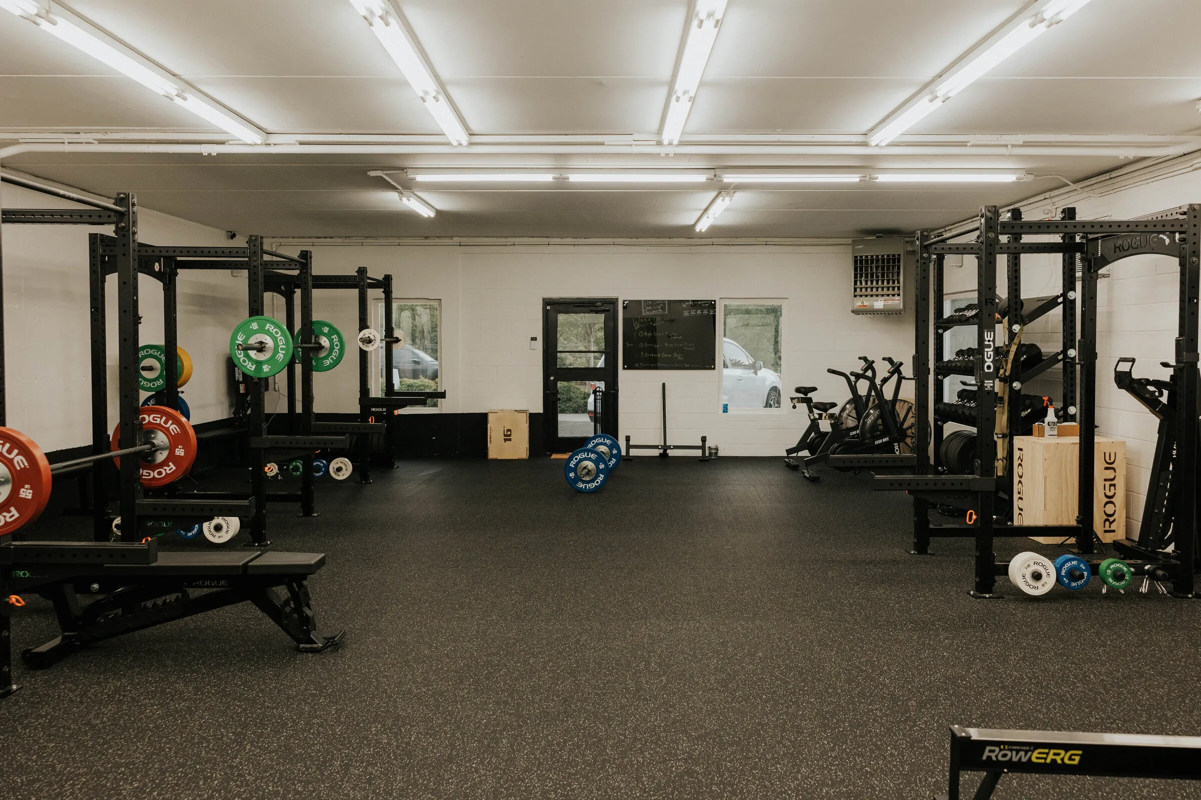 The Simply Strong Gym training floor, racks along the wall